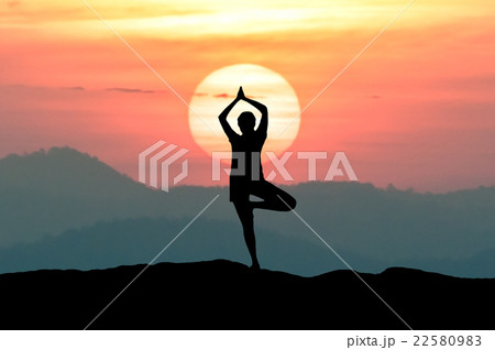 Silhouette young woman practicing yoga with sunset 22580983