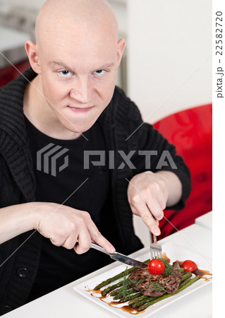 Young man sitting at sushi bar, smiling Young man sitting at sushi bar, smiling 22582720