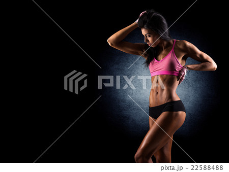 Brutal athletic woman pumping up muscles dumbbells 22588488