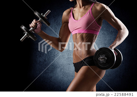 Brutal athletic woman pumping up muscles dumbbells 22588491