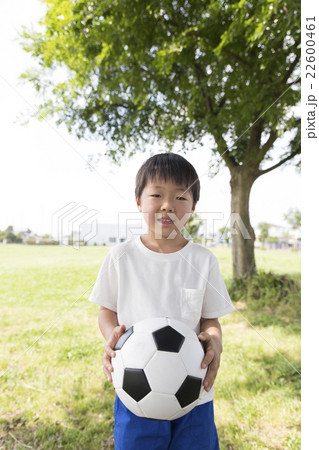 サッカーボールを持つ男の子 6歳7歳 小学生 幼稚園児 屋外 緑 カメラ目線の写真素材
