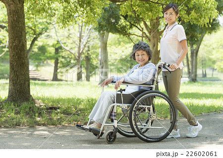 車椅子を押す女性とシニアの写真素材