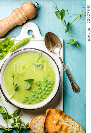 Light summer green pea cream soup in bowl with 22627846