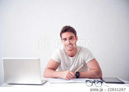 Cheerful smiling  man sitting at the table  22631267