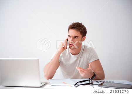 Cheerless handsome man sitting at the table  22631270