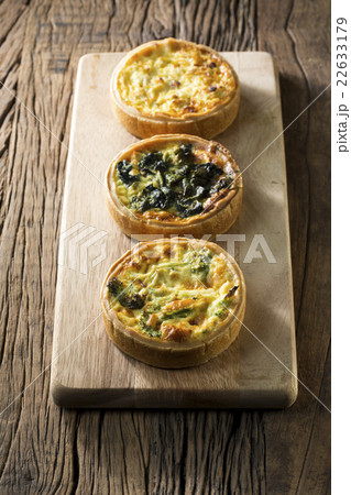 Three homemade quiche's on a rustic background. 22633179
