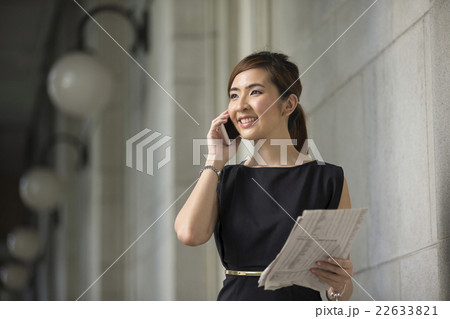 Asian businesswoman standing outside using a mobile phone. 22633821