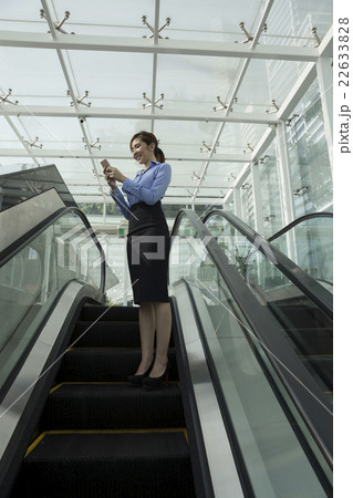 Asian business woman using her Smart phone outdoors. Asian business woman using her Smart phone outdoors. 22633828