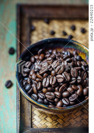 Dark coffee beans in ceramic bowl on table Dark coffee beans in ceramic bowl on table 22640215