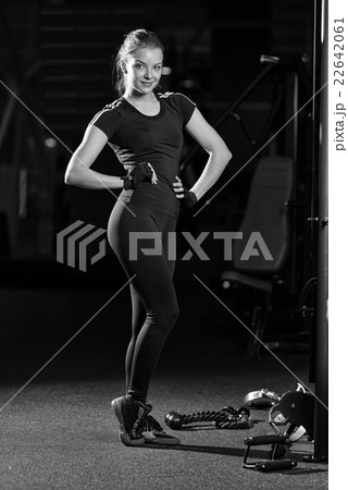 Woman at the sport gym doing arms exercises on a Woman at the sport gym doing arms exercises on a 22642061