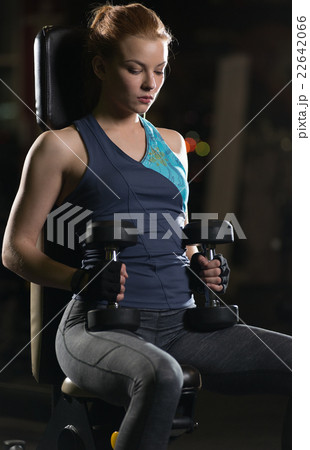 Young woman lifting the dumbbells Young woman lifting the dumbbells 22642066