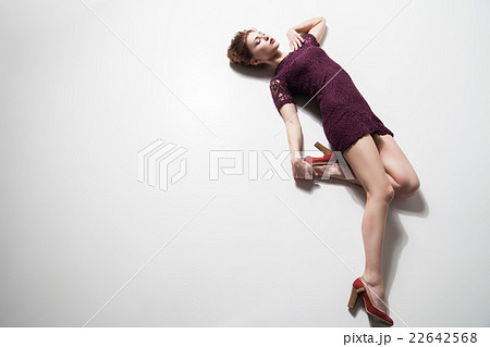 Woman in dress and heels posing on floor Woman in dress and heels posing on floor 22642568
