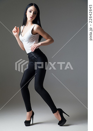 Slim black-haired woman posing on high heels 22642645