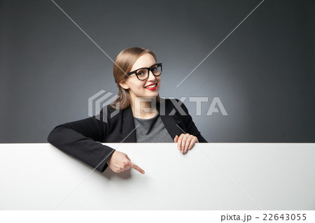 Smiling woman pointing at blank space Smiling woman pointing at blank space 22643055