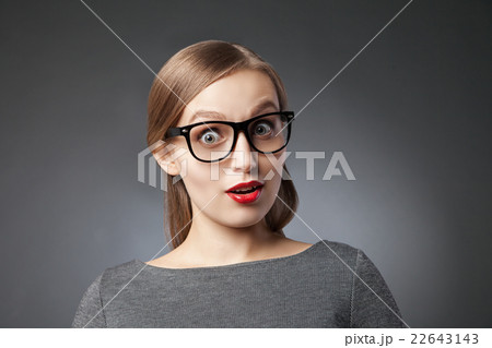 Wide-eyed astonished woman over grey background 22643143