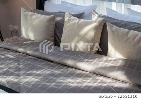 modern bedroom with brown pillows 22651310