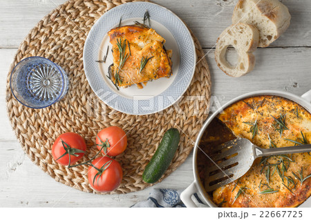 Eating moussaka in the white table with tableware  Eating moussaka in the white table with tableware  22667725