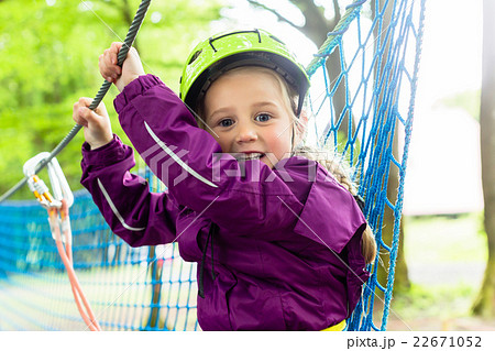Girl climbing in high rope course Girl climbing in high rope course 22671052