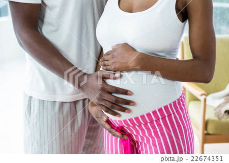 Pregnant couple embracing in bedroom Pregnant couple embracing in bedroom 22674351