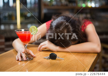 Drunk woman driver leaning on counter with her cocktail Drunk woman driver leaning on counter with her cocktail 22676444