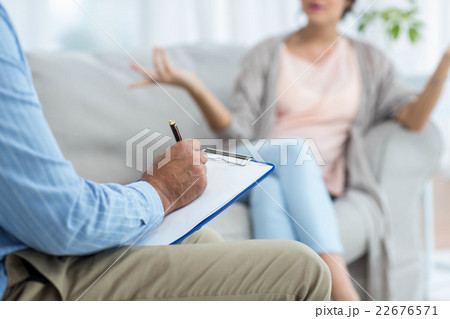 Doctor writing on clipboard while consulting pregnant woman 22676571