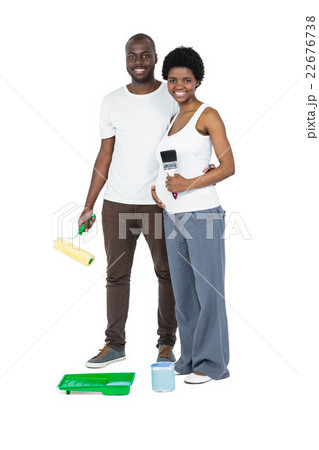 Pregnant couple holding roller paint and paint brush 22676738