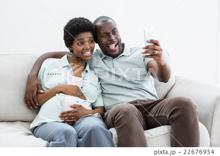 Pregnant couple taking a selfie on mobile phone Pregnant couple taking a selfie on mobile phone 22676954