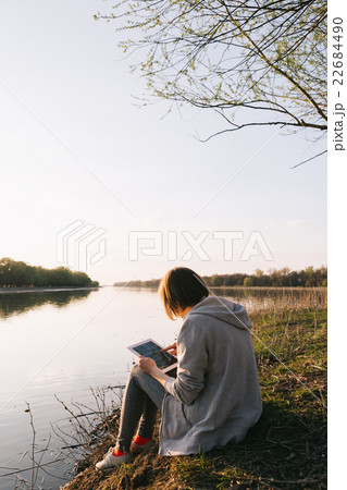 girl working with tablet at the river 22684490