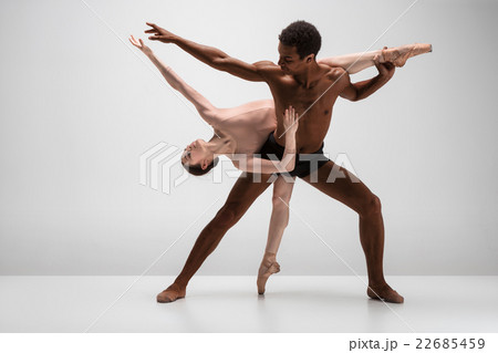 Couple of ballet dancers posing over gray 22685459