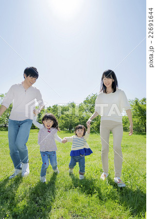 新緑の公園を歩く4人家族 22691644