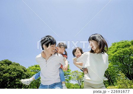 新緑の公園を歩く4人家族 22691677