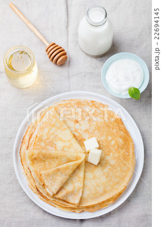 Thin crepes or pancakes with butter and sour cream 22694145