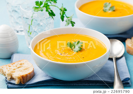 Pumpkin and carrot soup with cream and parsley 22695790