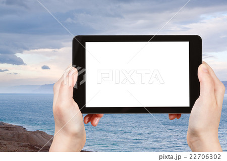 tourist photographs blue sunrise over Dead Sea 22706302