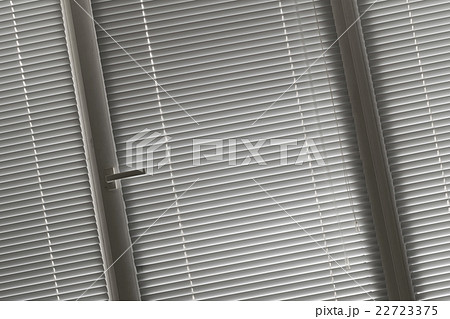 slanted view on grey horizontal jalousie in window 22723375