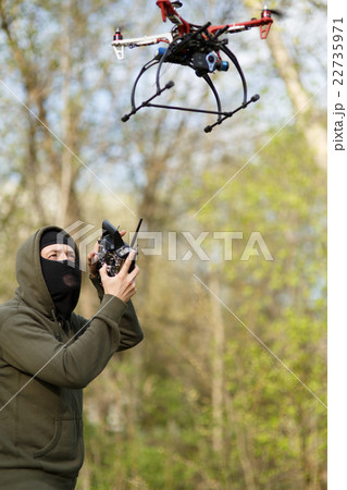 Man in mask operating a drone with remote control. Man in mask operating a drone with remote control. 22735971