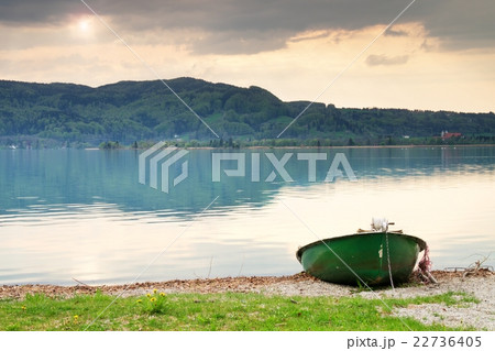 Abandoned fishing paddle boat on bank.Morning lake 22736405