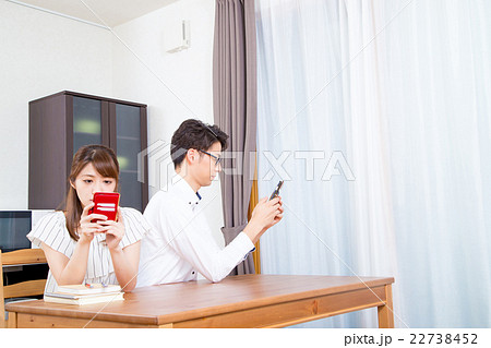スマホに夢中なカップル　スマホばかり見る夫婦　スマホ中毒　 22738452