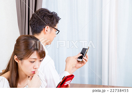 スマホに夢中なカップル　スマホばかり見る夫婦　スマホ中毒　 22738455