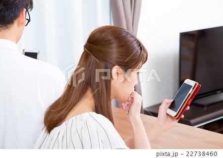 スマホに夢中なカップル　スマホばかり見る夫婦　スマホ中毒　 22738460