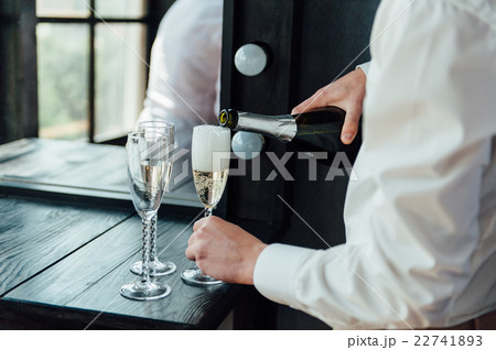 men pour champagne into glasses 22741893