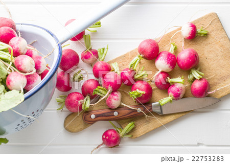 Fresh radishes on old cutting board. 22753283