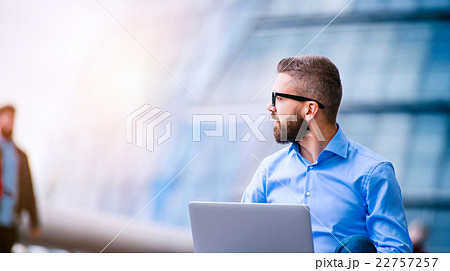 Manager with laptop, sitting on stairs, London 22757257