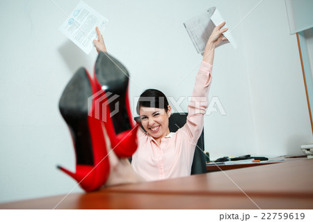 Relaxed businesswoman with legs on the desk 22759619