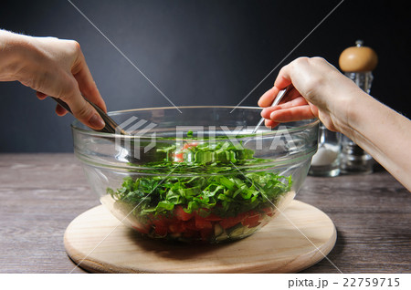 Girl stirs cooked vegetarian vegetable salad Girl stirs cooked vegetarian vegetable salad 22759715