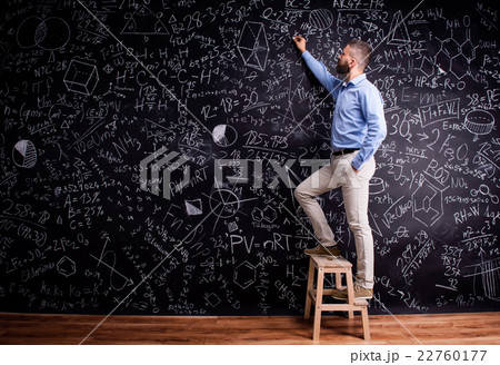 Man writing on big blackboard with mathematical Man writing on big blackboard with mathematical 22760177