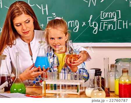 Child girl and chemistry teacher holding flask in 22760787