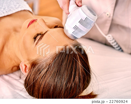 Young woman receiving electric facial massage. Young woman receiving electric facial massage. 22760924