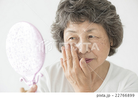 手鏡を見るシニア女性 22766899