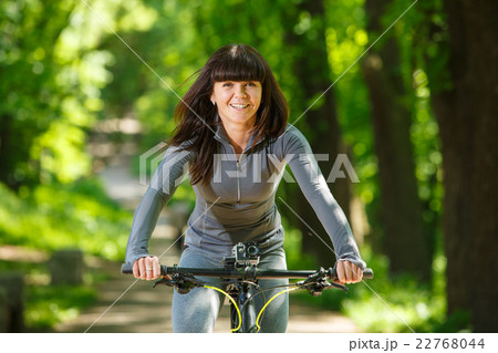 cyclist woman riding a bicycle in park 22768044